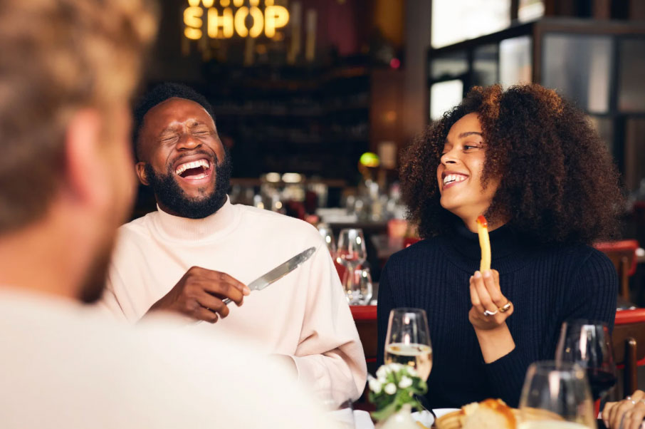 Image of a man and woman sitting at a table in a restaurant and laughing